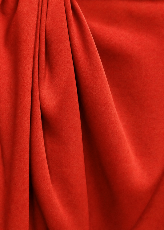 Pliegues de la tela crepe saten reciclado color rojo rubi 