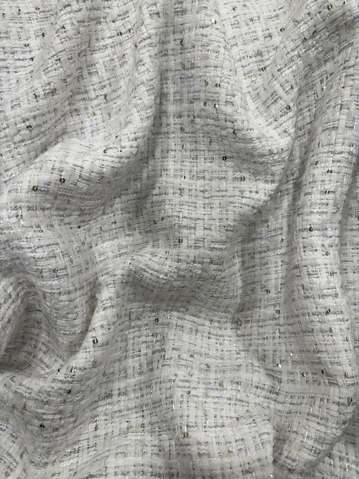 Detalle de la caída del tweed blanco con lurex plata y lentejuela