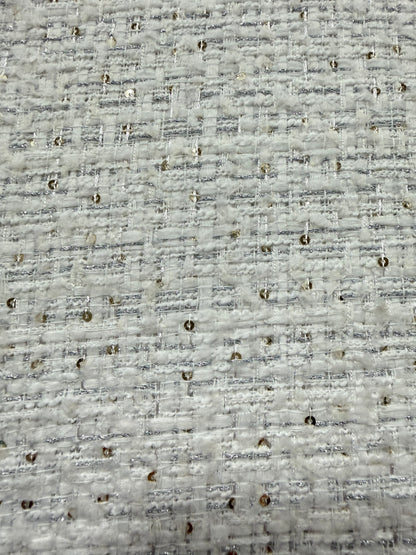 Primer plano del lurex plata y las lentejuelas sobre el tweed blanco