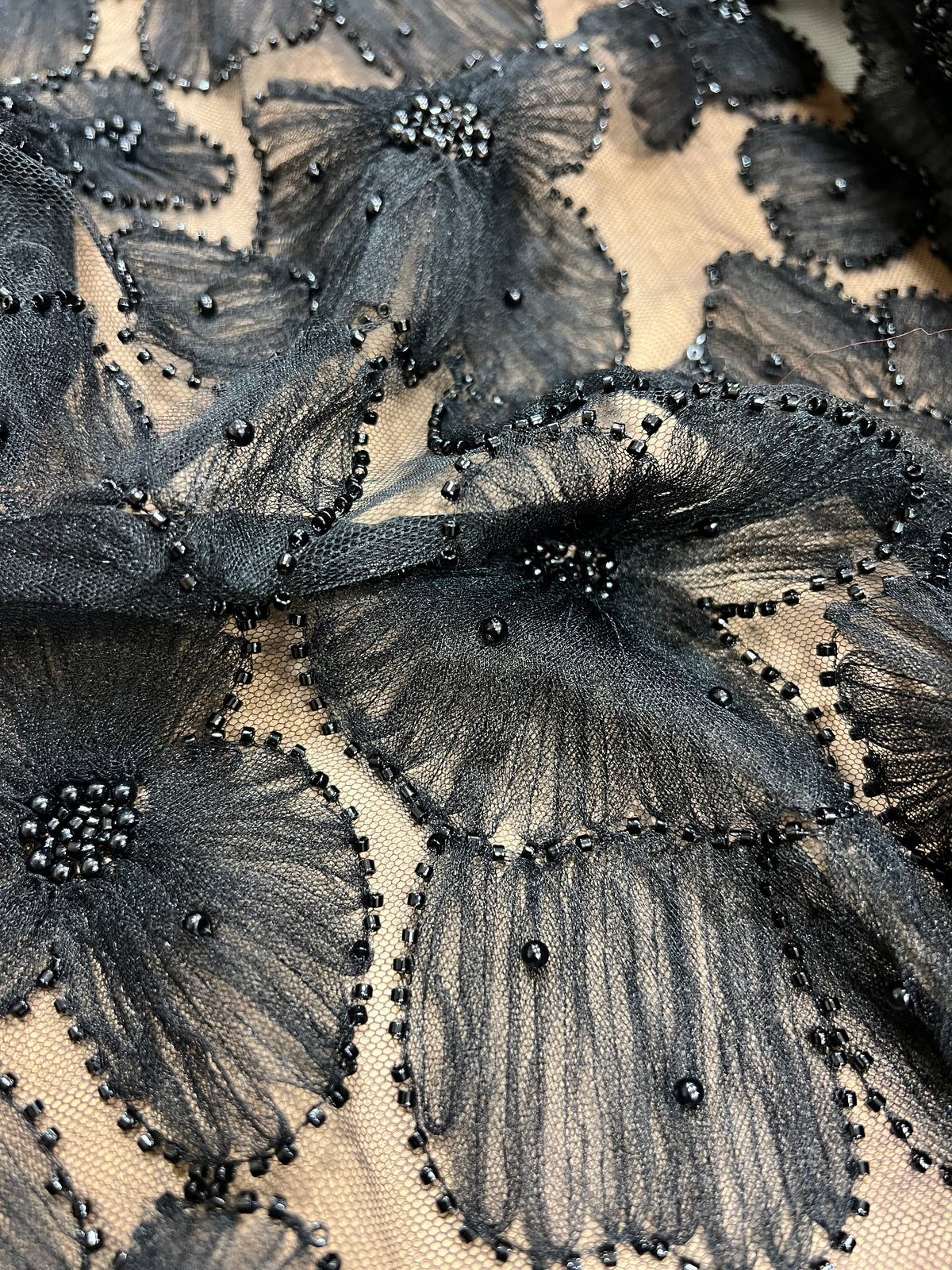 Detalle de la caída del tejido fantasía negro amapola oscura
