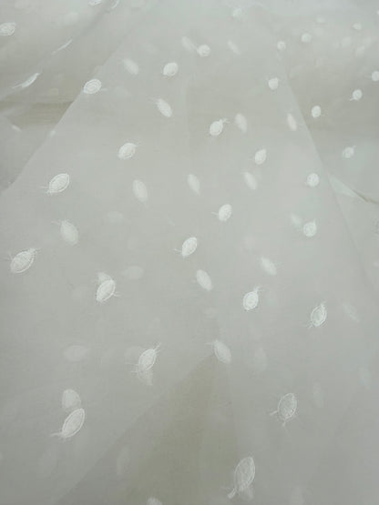 Primer plano de la textura de la organza de seda con topos bordados