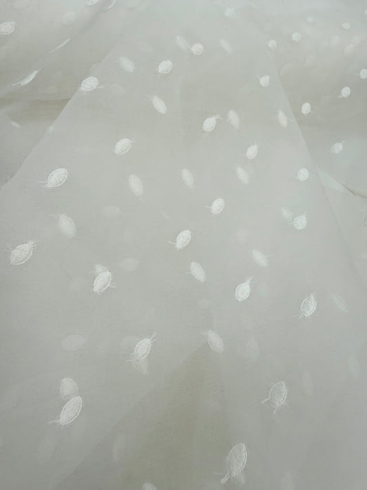 Primer plano de la textura de la organza de seda con topos bordados