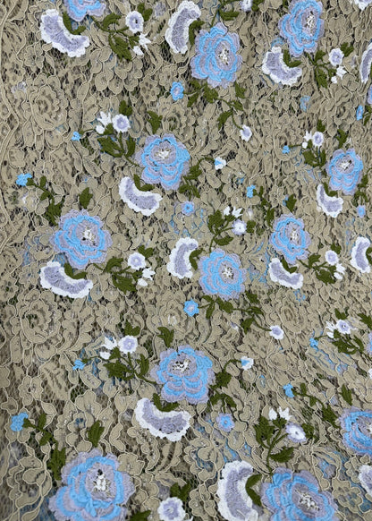 Patrón floral en encaje beige con bordado azul y verde