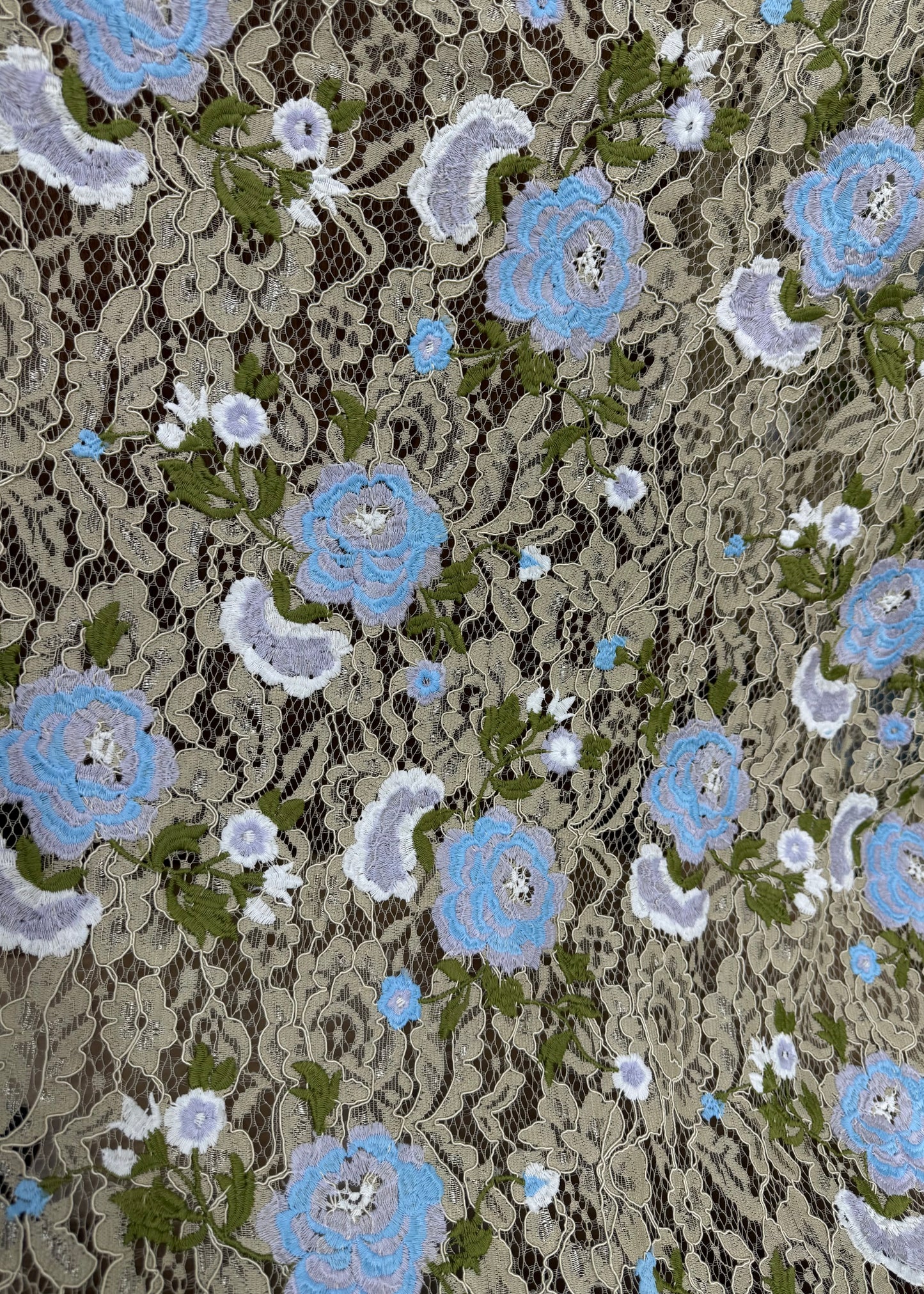 Encaje beige bordado con flores azules sobre base de encaje
