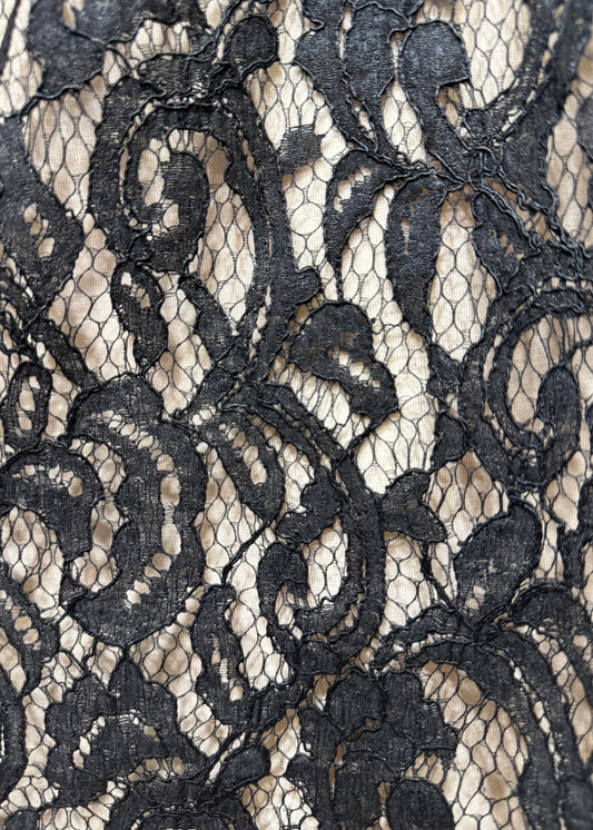 Detalle de encaje negro rebrodé con bordado en relieve sobre tul