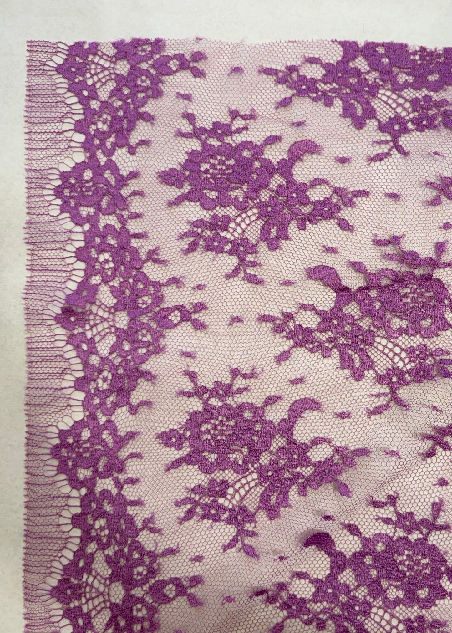 Detalle de encaje morado con diseño floral repetitivo