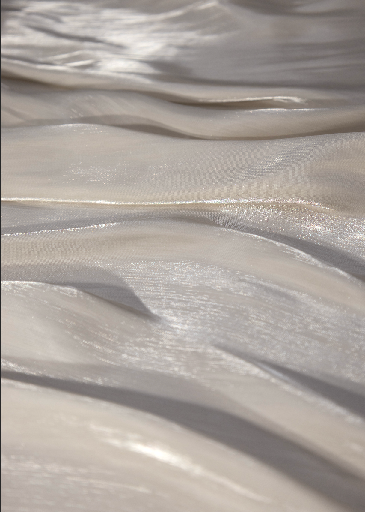 Tela gasa líquida blanca con acabado satinado y textura fluida en detalle