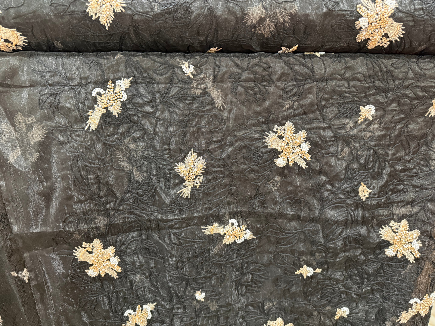 textura de organza bordada sobre tul negro con detalles de pedrería dorada