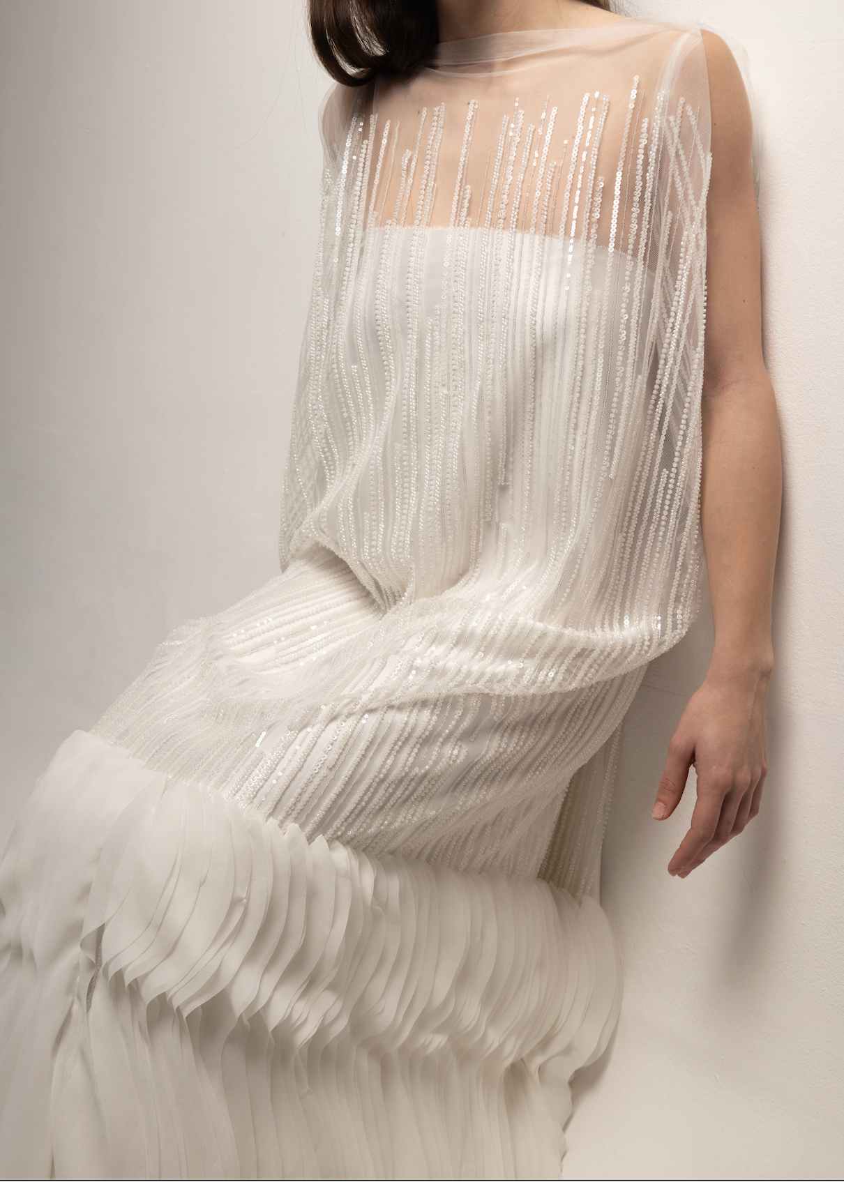 Tela tul con pedrería 3D en diseño editorial, vestido fluido con brillo elegante y líneas verticales.