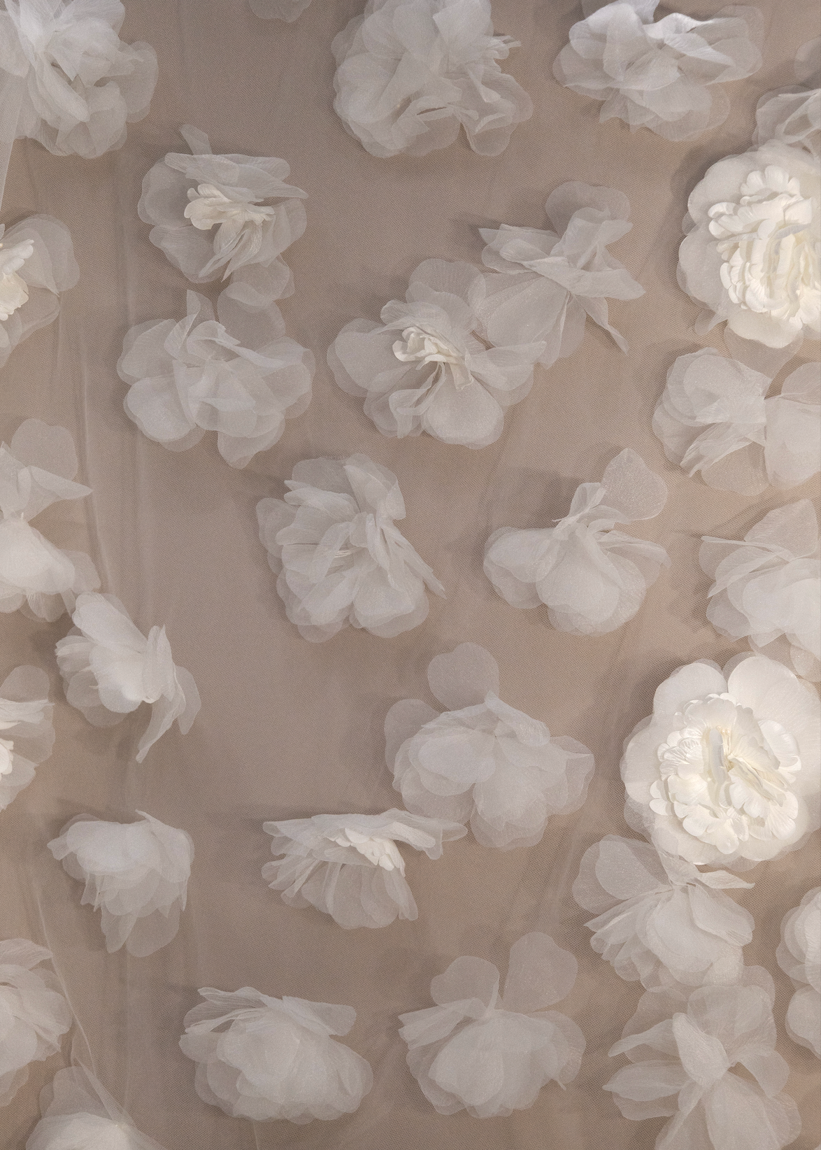 Tela tul con flores tridimensionales distribuidas, bordado floral en relieve ideal para confección de lujo.