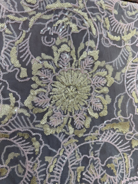Detalle de bordado floral con lentejuelas en tul rosa y dorado